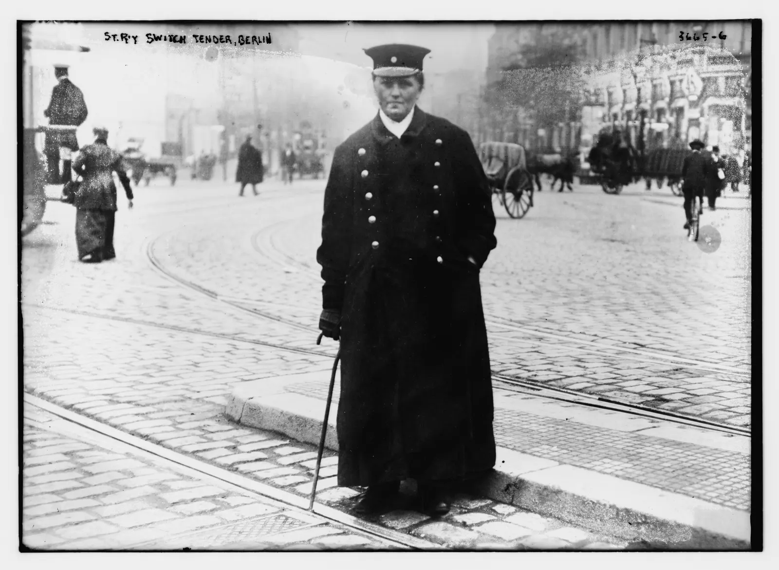 Uniformed Berlin street-railway switch tender standing at the tram rails with an iron rod, Bain News Service photograph